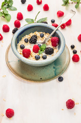 oat flakes with milk and berries in blue rustic bowl