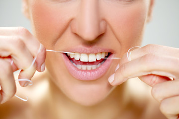 Fototapeta premium woman cleaning tooth with floss
