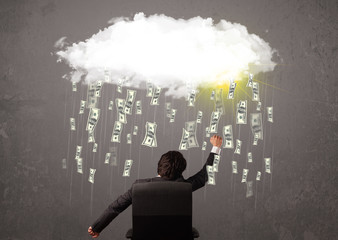 Business man in suit looking at cloud with falling money