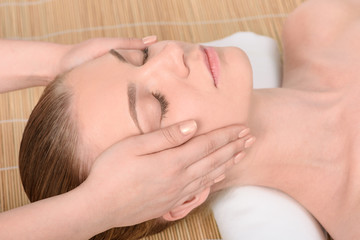 Fototapeta na wymiar Beautiful young woman getting relaxing head massage. Top view