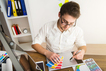 Young Handsome Graphic designer using graphics tablet to do his