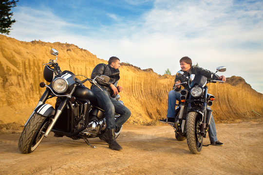 Fototapeta Two bikers on unknown motocycles talking on desert road