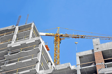 Naklejka premium Crane and building construction site against blue sky