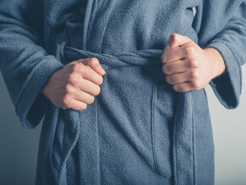 Man tying belt on his bathrobe