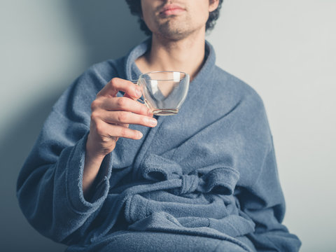 Man in bathrobe with empty cup