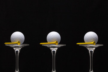 Three glasses of champagne and golf balls