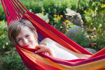 Lovely girl resting in a hammock