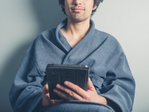 Man in bathrobe using tablet