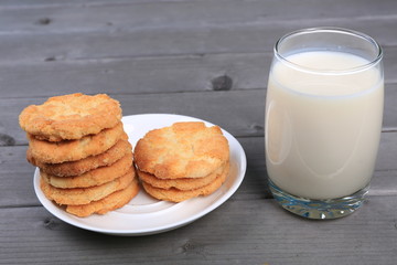 Glass of milk and cookies isolated on wood table