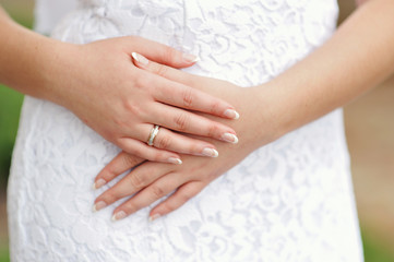 Fototapeta na wymiar Hands of the bride with a ring and manicure close-up