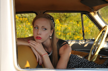 Closeup portrait of young woman inside old-fashioned car