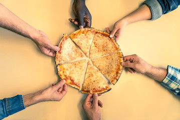 Six friends sharing a pizza in a restaurant