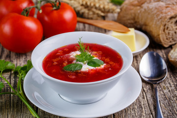 Tasty soup with bread on a wooden background.