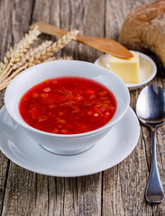 Tasty soup with bread on a wooden background.