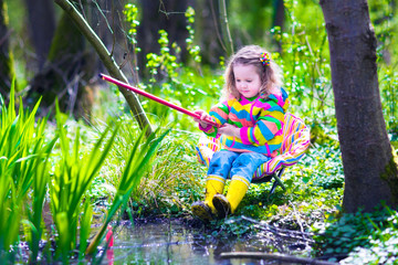Little girl fishing in a forest