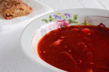 Beetroot soup with pie on the table