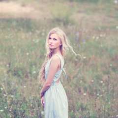 portrait of a beautiful blonde in a field in spring