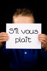 Child holding sign with French words S il Vous Plait - Please