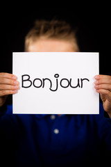 Child holding sign with French word Bonjour - Hello © Mikkel Bigandt