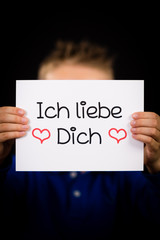 Child holding sign with German words Ich liebe Dich - I Love You