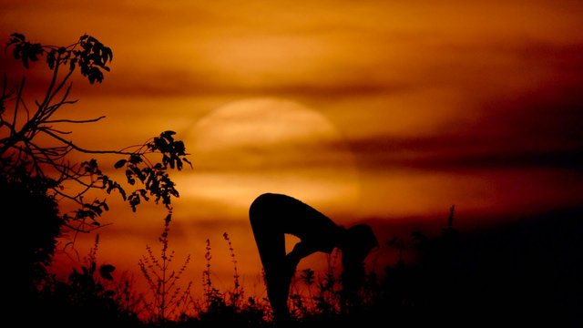 woman doing yoga at the sunset