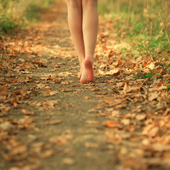 feet of beautiful hipster girl on autumn road