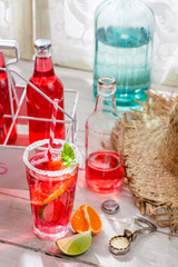 Tasty red summer drink with citrus fruit