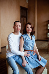 Man and woman dressed in denim sit at home