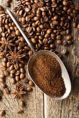 ground coffee in scoop and coffee beans on a wooden background