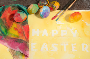 Uova colorate con pennelli e fiori su acquerello