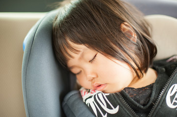 車の中で寝ている子供