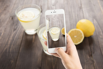 Taking photo of freshly squeezed lemon juice in glasses
