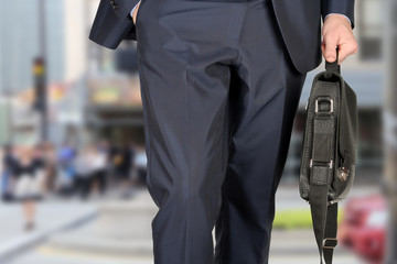 Businessman walking and holding  a  leather briefcase in his han