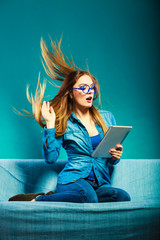 Girl hair blowing with tablet on couch