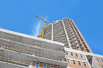 Crane and building construction site against blue sky