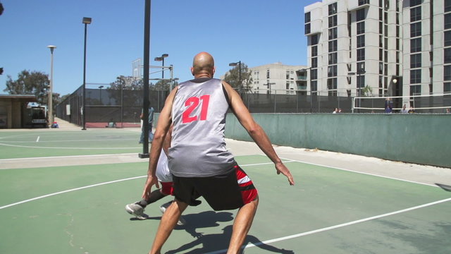 Two Basketball Players Playing One on One Outside with Scoring