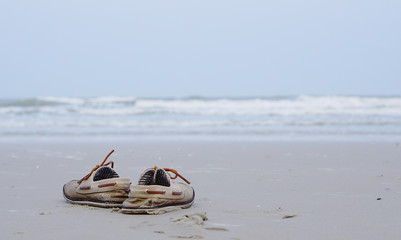 Working shoes on the beach with ocean background