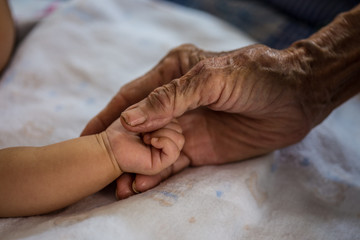 Hand of woman touching senior woman in clinic.