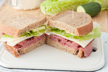 sandwich with roast beef, cheese, mustard and lettuce on whole