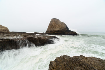 Ocean waves breaking up on coastal rocks