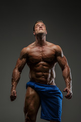 Fototapeta na wymiar Muscular guy posing in studio