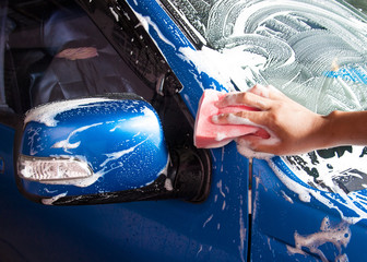 hand hold sponge over the car for washing