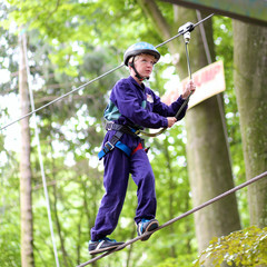 Happy boy climbing in adventure park