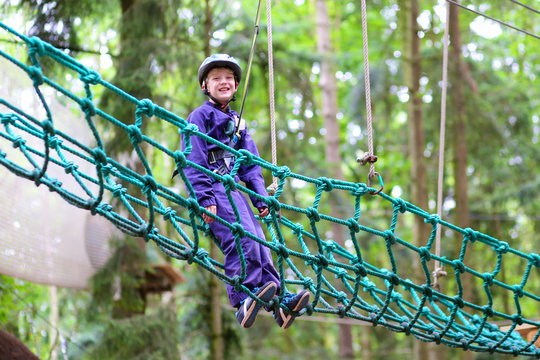 Happy boy climbing in adventure park