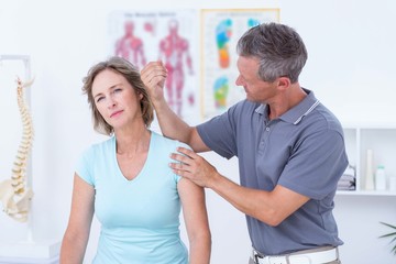 Doctor massaging his patient shoulders