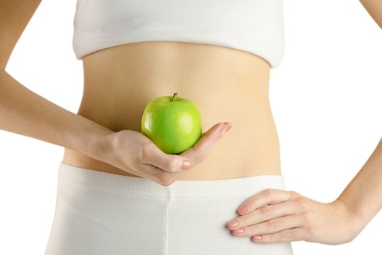 Slim woman holding green apple