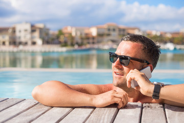 Man talking on phone while relaxing in the swimming pool