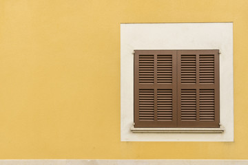 Traditional brown blinds in the South with yellow wall