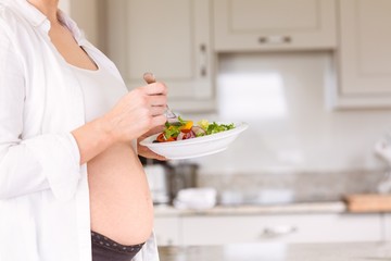 Pregnant woman eating a salad