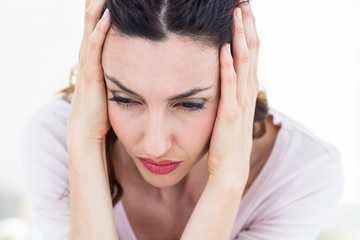 Sad brunette sitting on the couch